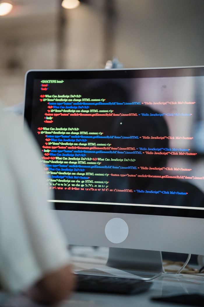 Crafting Captivating Headlines: Your awesome post title goes here A close-up of a computer screen displaying colorful coding script in an office environment.
